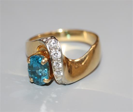 A modern 750 yellow metal, blue zircon and diamond set dress ring, size T.